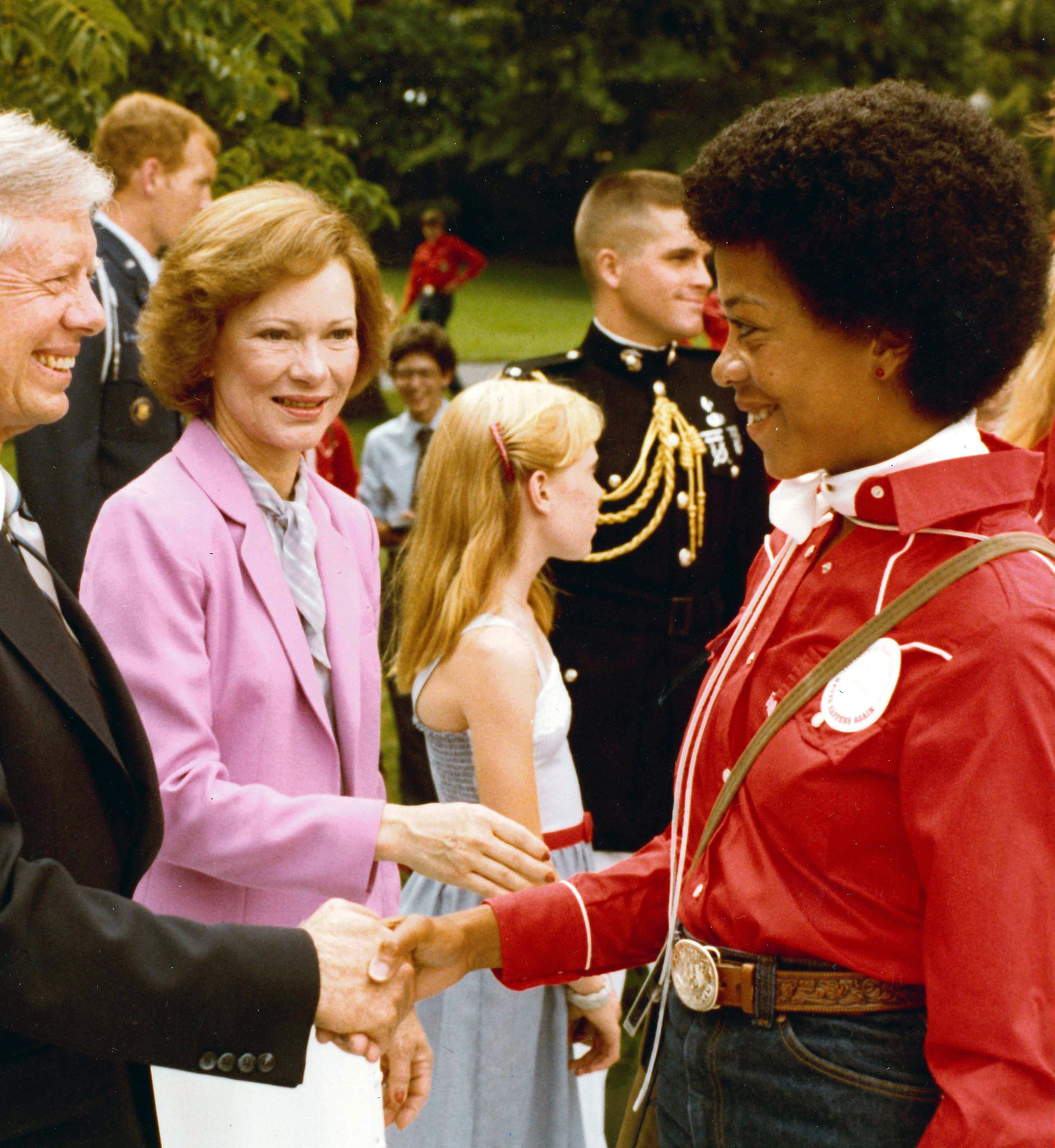 Robin Campbell-Bennett shaking hands with former President Jimmy Carter.