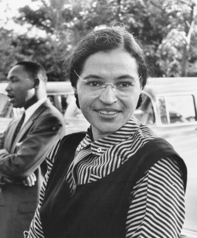 black and white picture of rosa parks with glasses smiling at camera