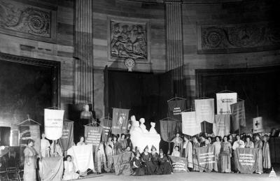 black and white photo of women in the rotunda with flags protesting
