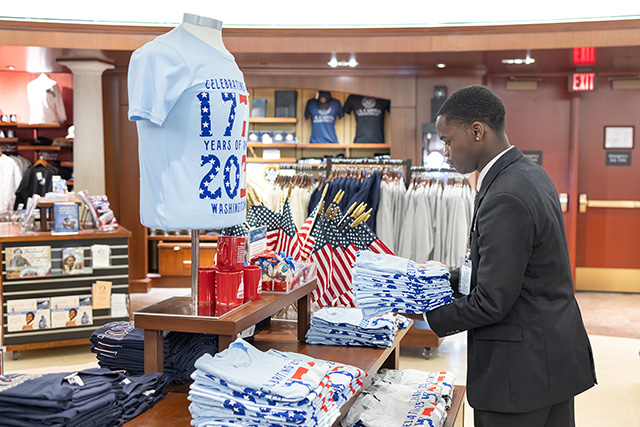 Sales associate readies t-shirts in the gift shop. 