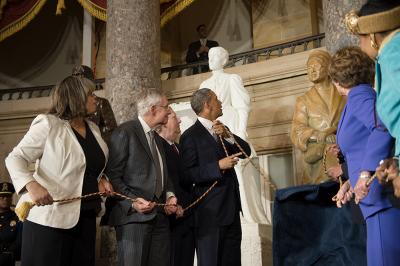 president obama and 4 others pulling the rope to reveal rosa park's bronze bust