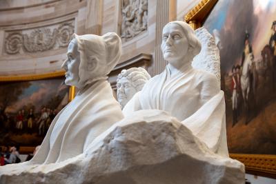 two white marble busts of two women looking off to the right and left