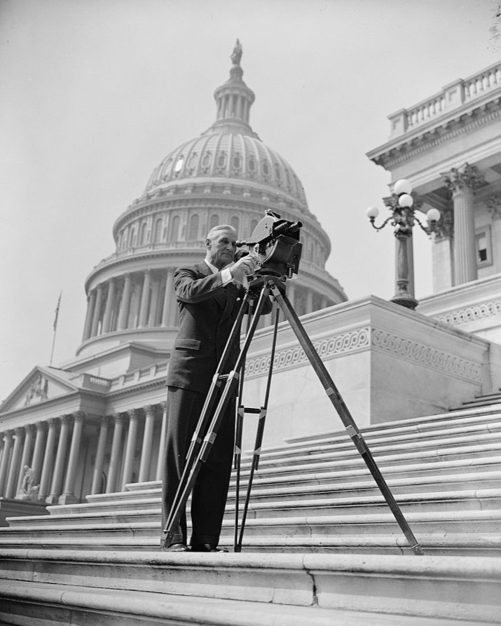 Black and white photo of a man with a film camera on the Capitol steps