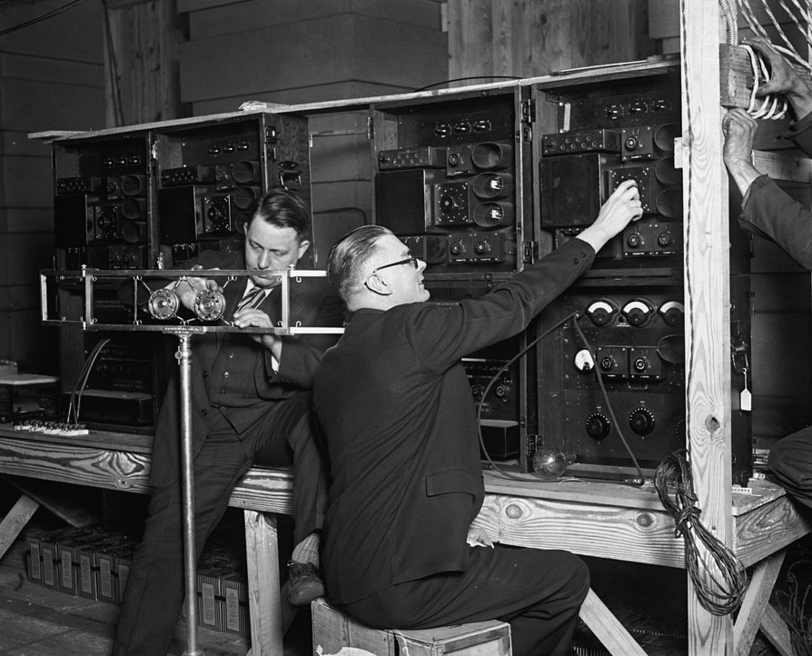 Black and white photo of two men at a radio channel terminal