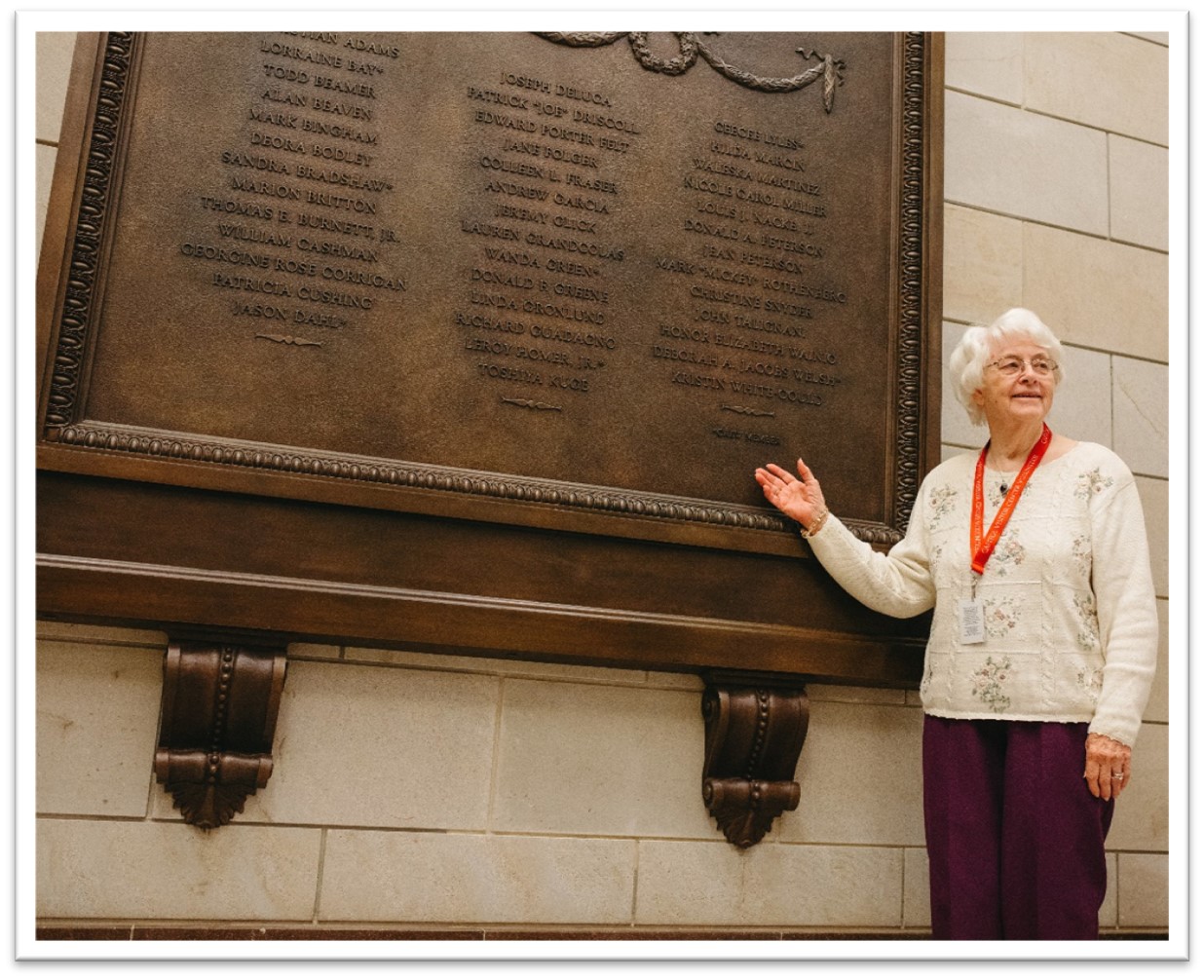 Woman standing in front of large wall plaque.