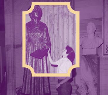 purple tinted photograph of a women reaching up to touch a statue of Jeanette Rankin