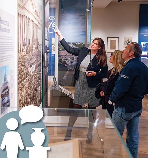 People standing looking at information on the wall. 
