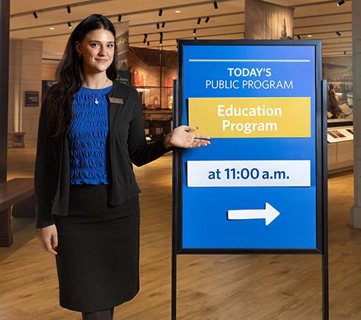 Woman standing next to info board. 