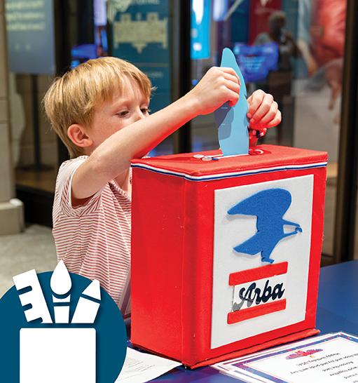 a child drops a blue paper feather into a red Arba mailbox