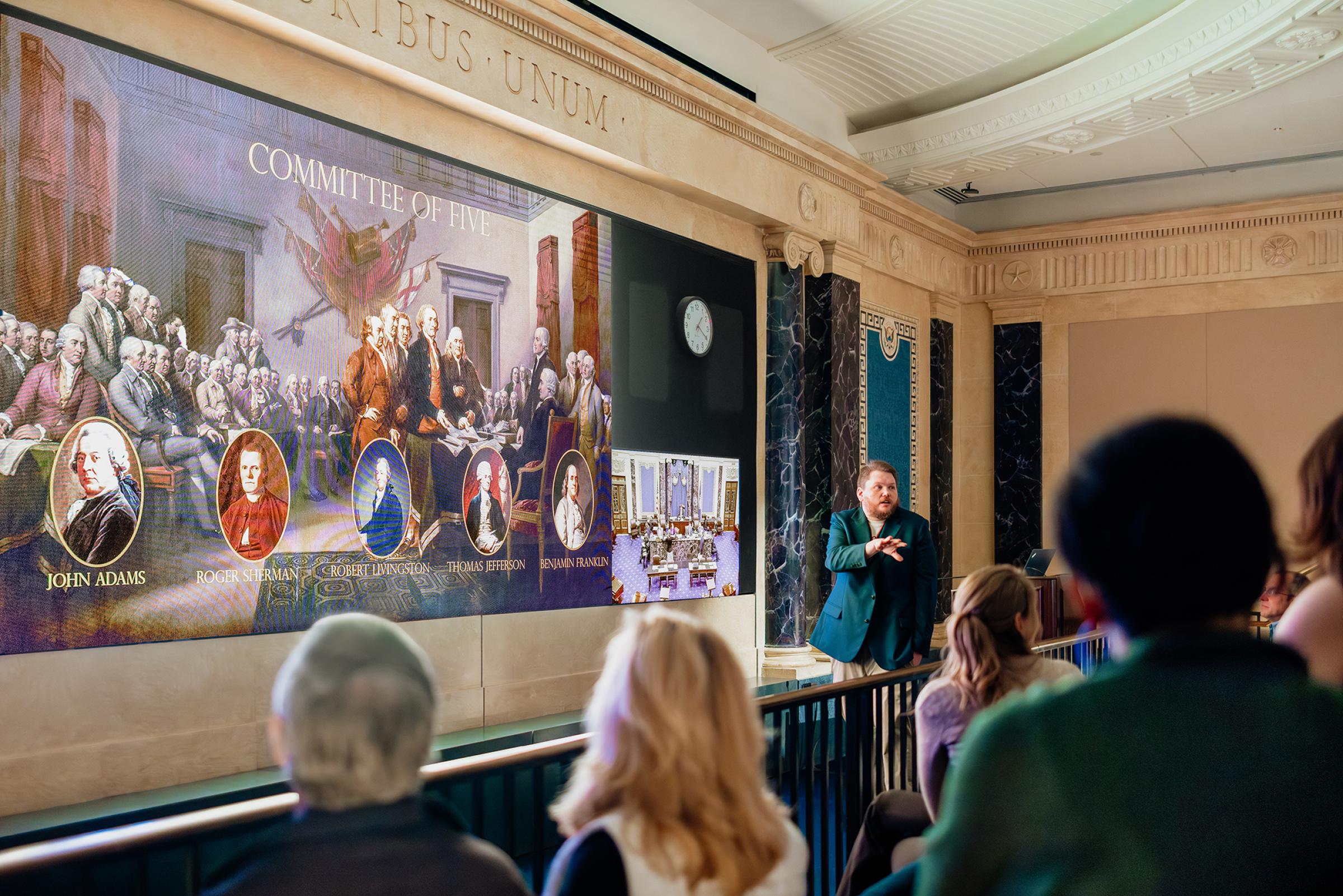 A man giving a presentation to visitors. 