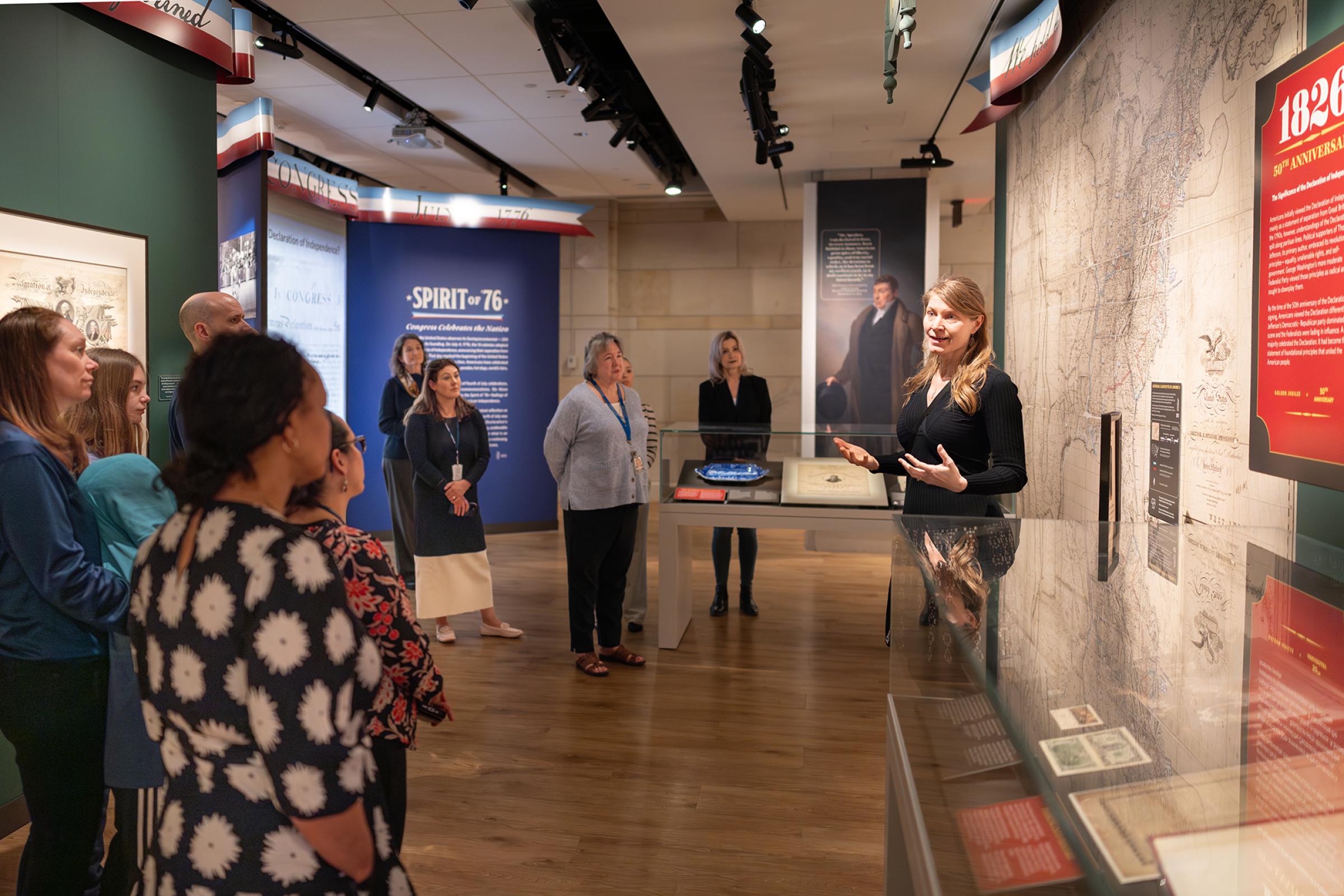 A woman giving a presentation to visitors. 