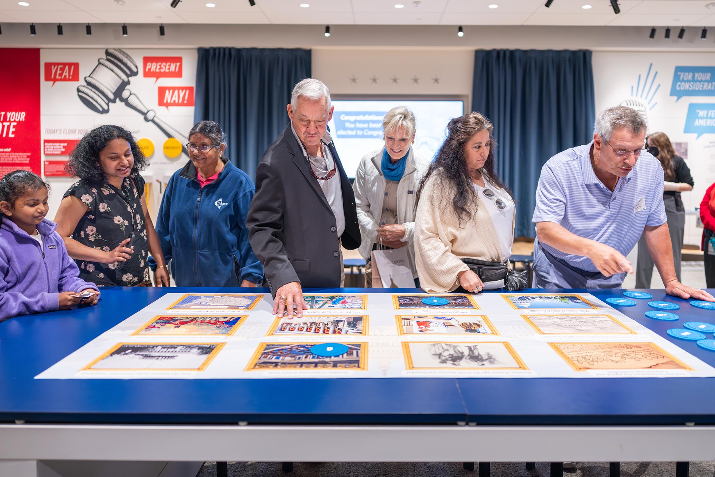 People at a table with images on it. 