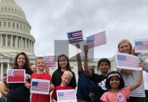 Children outside the US Capitol waving flags