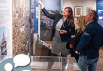 People standing looking at information on the wall.