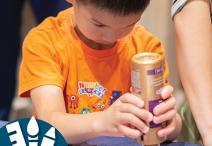 Child gluing stars on a paper American flag. 