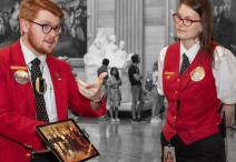 one Visitor Guide wearing a red blazer and one Visitor Guide wearing a red vest