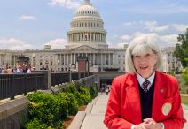 Visitor Guide in a red blazer standing outside in front of the U.S. Capitol