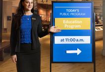 Woman standing next to info board. 
