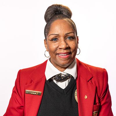 Visitor Guide Adriane wearing a red blazer and smiling directly at the camera