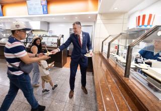 Architect of the Capitol Thomas E. Austin hands out plates with cake to visitors